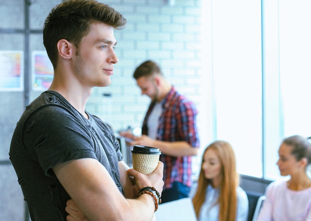 Homme d'affaires avec des collègues en arrière-plan au bureau