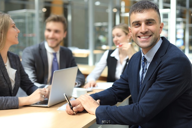 Homme d'affaires avec des collègues en arrière-plan au bureau.