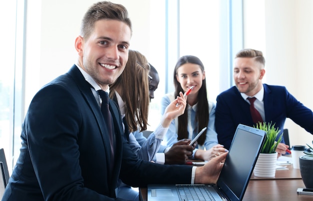 Homme d'affaires avec des collègues en arrière-plan au bureau