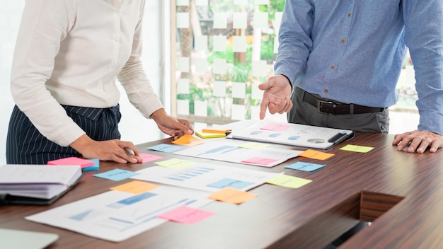 Homme d'affaires, coller des notes colorées à un brainstorming sur le projet de travail de table