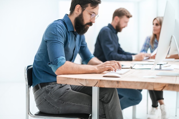 Photo homme d & # 39; affaires concentré travaillant sur un ordinateur au bureau