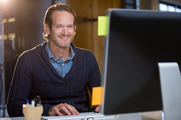 Photo homme d'affaires confiant à l'aide d'ordinateur au bureau