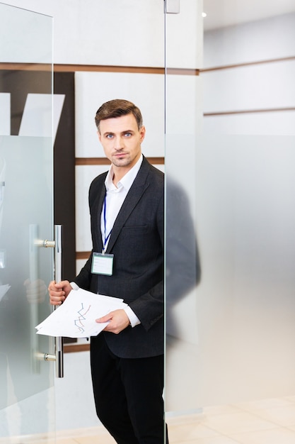 homme d'affaires confiant en costume noir entrant dans le bureau