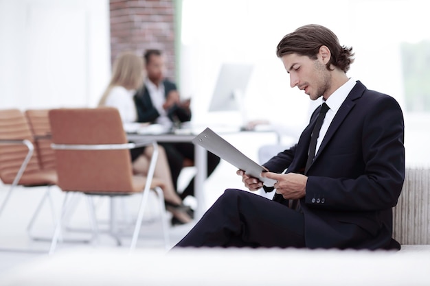 Homme d'affaires confiant étudiant le document dans son bureau