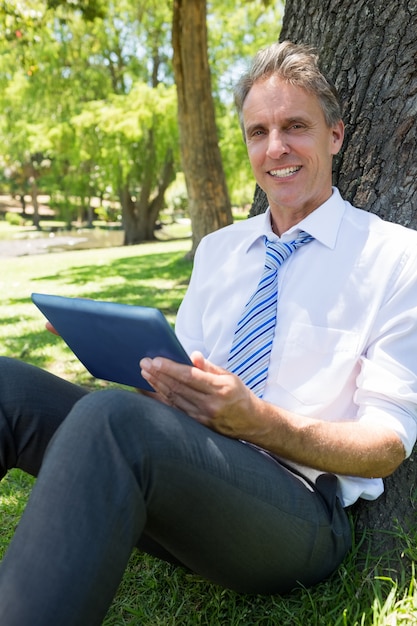 Homme d&#39;affaires confiant avec tablette numérique dans le parc