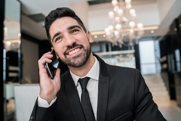 Homme affaires, conversation téléphone, dans, hall hôtel