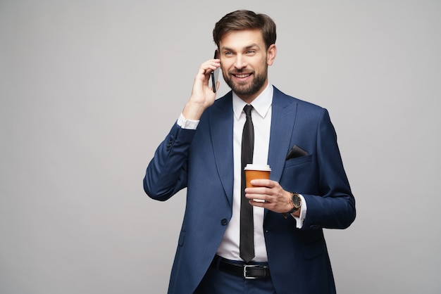 Homme affaires, conversation téléphone, et, tenue, tasse café, sur, mur gris