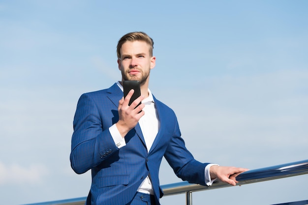 Homme d'affaires en costume d'affaires avec la nouvelle technologie de téléphonie mobile