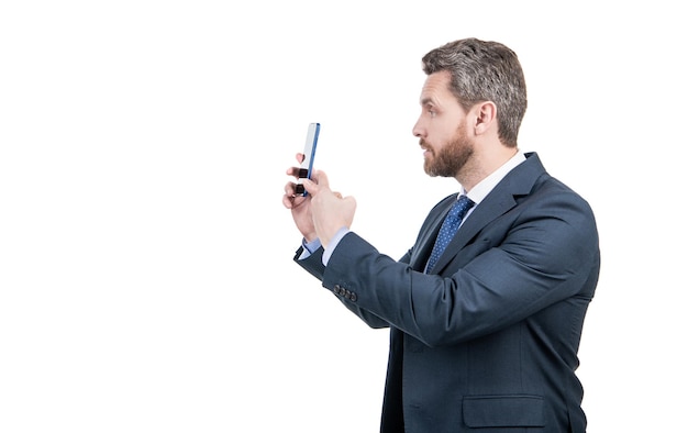 Homme d'affaires en costume d'affaires pointer du doigt sur un téléphone mobile isolé sur un espace de copie blanche pointant