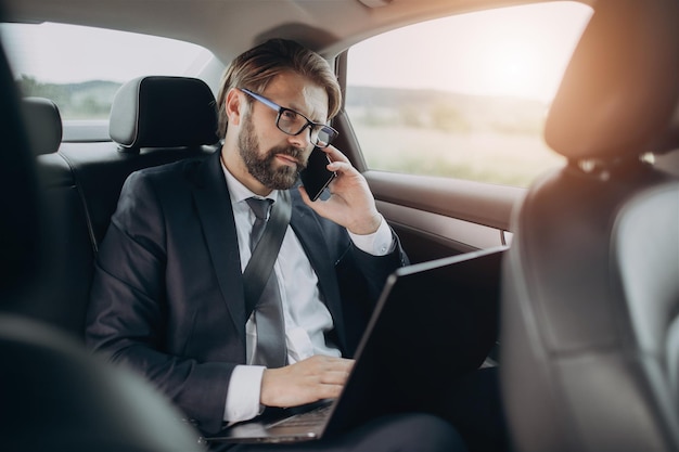 Homme d'affaires en costume ayant une conversation sur mobile en voiture