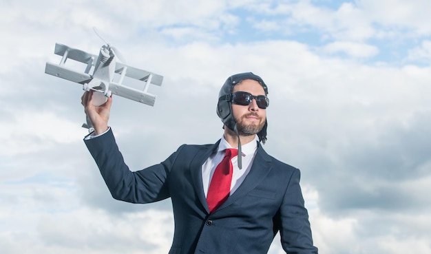 Homme d'affaires en costume et chapeau de pilote lancement avion jouet réalisation