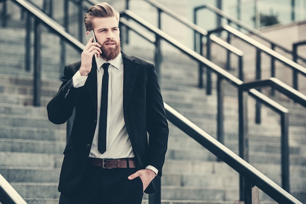 Homme D'affaires En Costume Classique Parle Sur Téléphone Mobile.