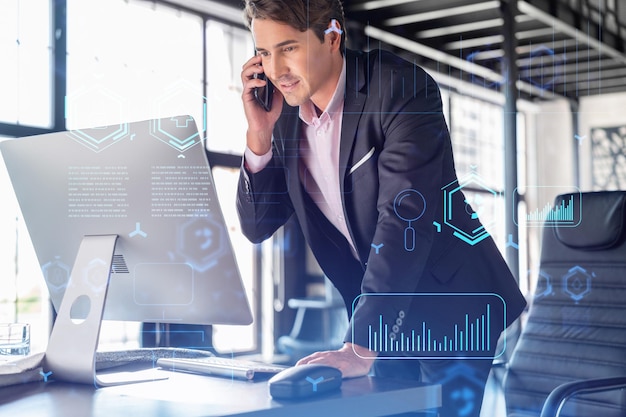 Un homme d'affaires en costume a une conférence téléphonique pour optimiser le développement en impliquant de nouvelles technologies dans les interconnexions des processus commerciaux et un hologramme de haute technologie sur fond de bureau avec des fenêtres panoramiques