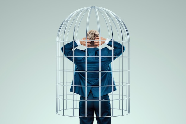 Homme d'affaires en costume dans une cage en métal Les possibilités sont limitées métaphore d'affaires esprit problèmes de prison difficultés