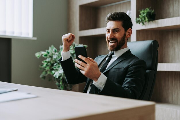 Homme d'affaires avec costume élégant assis au bureau de l'ordinateur au bureau