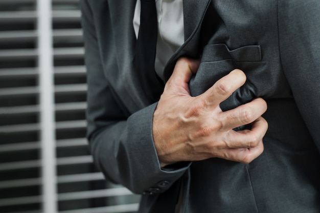 Homme d&#39;affaires en costume gris ayant une crise cardiaque