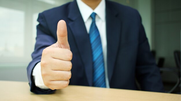 homme d&#39;affaires en costume lève sa main faire le superbe signe au bureau