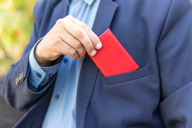 Un homme d'affaires en costume noir montre sa carte d'identité Un fonctionnaire de haut rang montre son document rouge Carte d'identité vierge d'immunité parlementaire pour test et conception