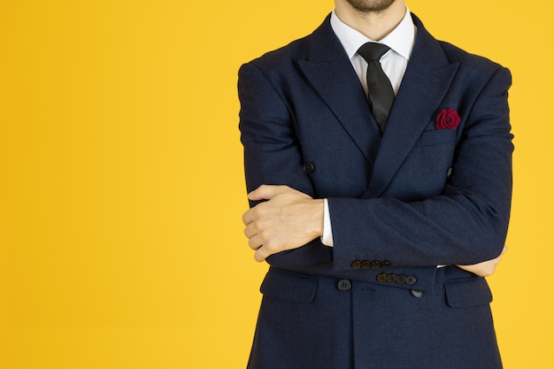 homme d'affaires en costume posant avec les bras croisés