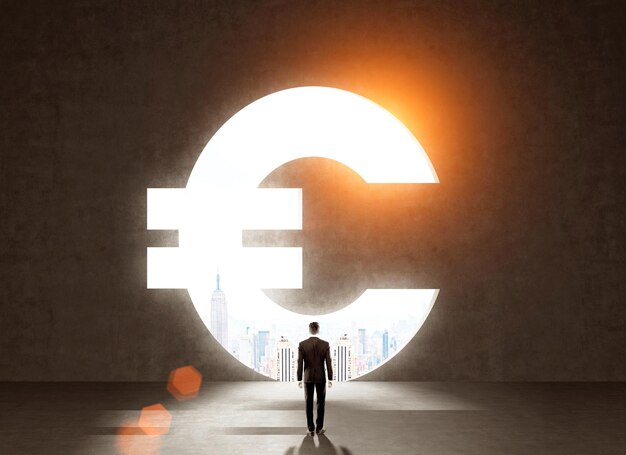 Homme d'affaires en costume sombre devant le symbole de l'euro