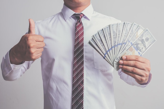 Photo homme d'affaires en costume tenant un concept d'argent de cent billets de 100 dollars