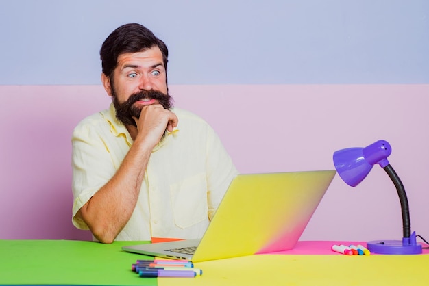 Homme d'affaires curieux avec un ordinateur portable au bureau