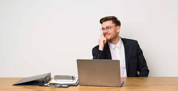 Homme d'affaires dans un bureau avec des lunettes et souriant