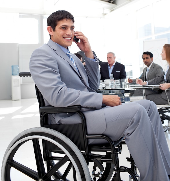 Homme d&#39;affaires dans un fauteuil roulant au téléphone lors d&#39;une réunion