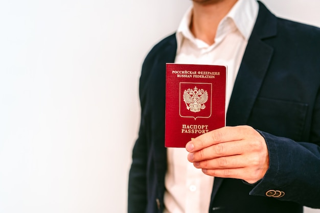 Un homme d'affaires dans une veste et une chemise détient un passeport russe