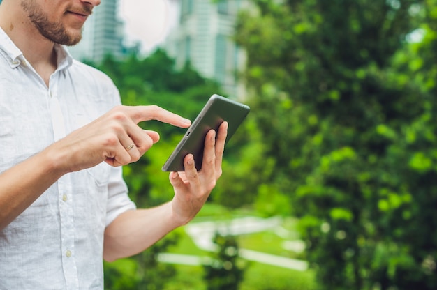 Homme affaires, dans, vêtements décontractés, utilisation, tablette, dans parc