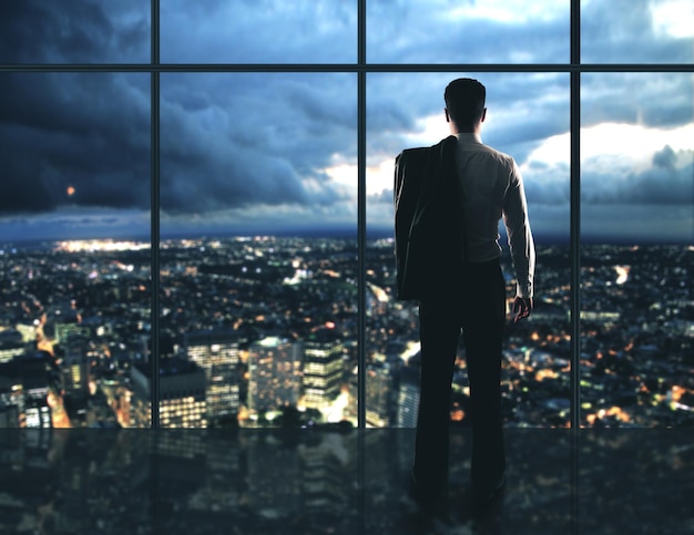 Homme d'affaires debout au bureau de nuit