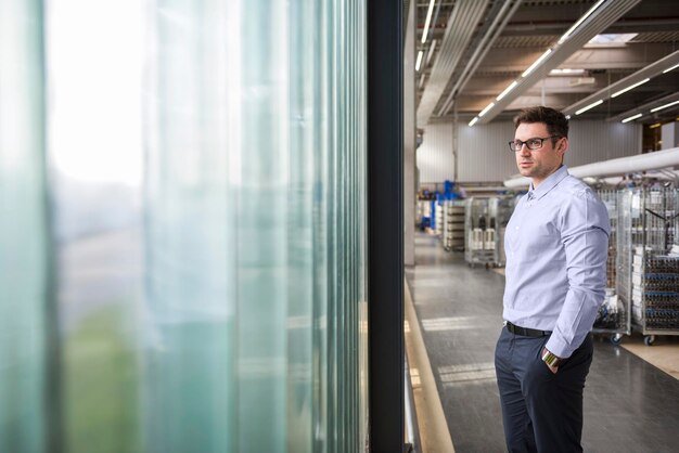 Homme d'affaires debout dans l'atelier d'usine