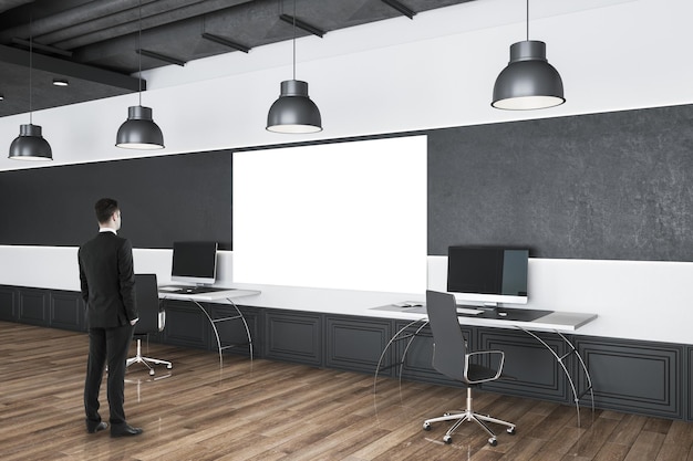 Photo homme d'affaires debout dans un intérieur de bureau moderne avec deux affiches vides