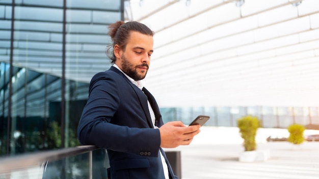 Homme d'affaires debout à l'extérieur du smartphone