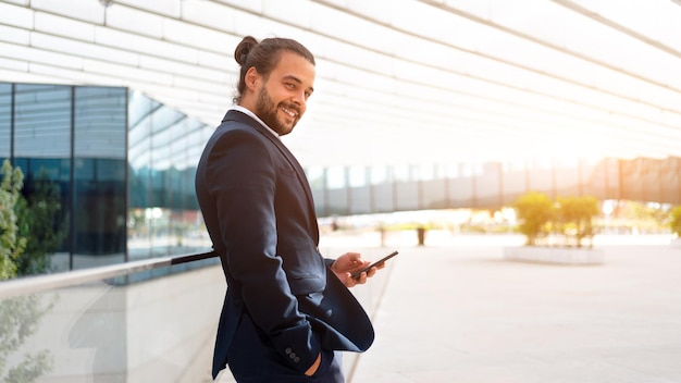 Homme d'affaires debout à l'extérieur du smartphone