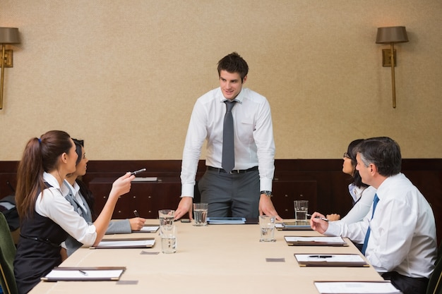 Homme d&#39;affaires debout à la tête de la table