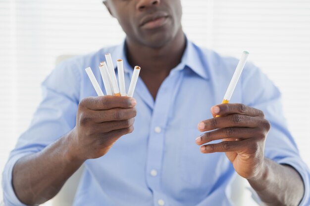 Homme d&#39;affaires de décider entre les cigarettes électroniques ou normales