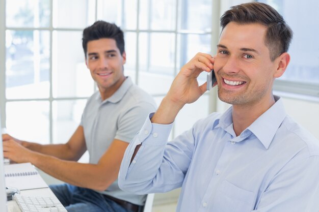 Homme d&#39;affaires décontracté, souriant à la caméra sur le téléphone