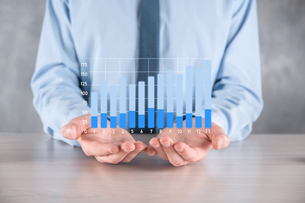 Homme d'affaires détenant un graphique avec une croissance positive des bénéfices.