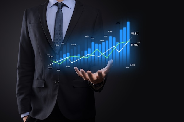 Homme d'affaires détenant des graphiques holographiques et des statistiques boursières gagner des bénéfices