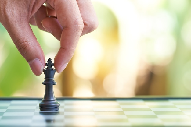 Homme d&#39;affaires détenant un roi d&#39;échecs est placé sur un échiquier