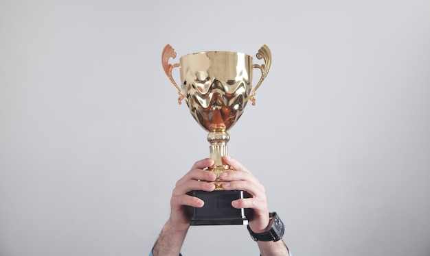 Photo homme d'affaires détenant le trophée d'or. la réussite des entreprises