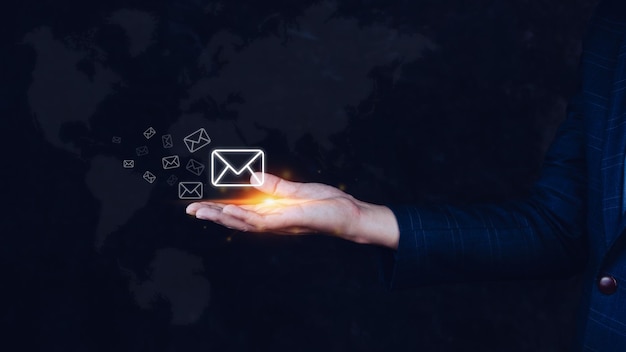 Homme d'affaires détenant la vérification des e-mails en ligne avec la technologie d'interface virtuelle de fond de carte du mondeMessage en ligne de marketing direct Concept de communication de courrier électronique par e-mail