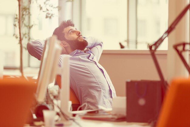 Photo homme d'affaires détendu sur le lieu de travail tôt le matin se détendre au bureau de démarrage