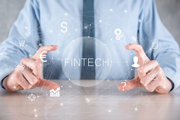 Homme d'affaires détenir Fintech - concept de technologie financière. Paiement bancaire d'investissement commercial. Investissement en crypto-monnaie et monnaie numérique. Concept d'entreprise sur écran virtuel.