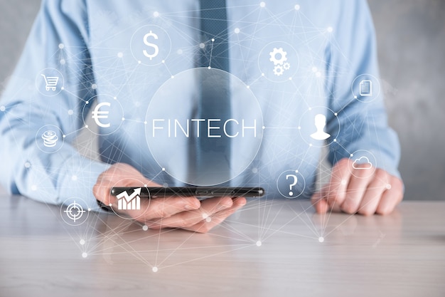 Homme d'affaires détenir Fintech - concept de technologie financière. Paiement bancaire d'investissement commercial. Investissement en crypto-monnaie et monnaie numérique. Concept d'entreprise sur écran virtuel.