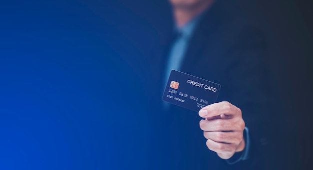 L'homme d'affaires détient une carte de crédit et utilise un téléphone portable. Concept d'achat en ligne, banque et achats en ligne à la maison. Gros plan.