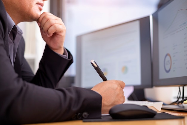 Un homme d'affaires discret réfléchit et regarde l'ordinateur au travail