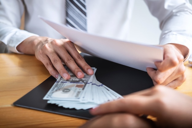 Homme d'affaires donnant de l'argent à des gens d'affaires pour donner le contrat de réussite