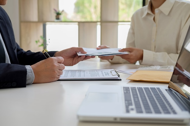 Homme d&#39;affaires donnant de l&#39;argent tout en faisant affaire à l&#39;accord d&#39;un contrat immobilier